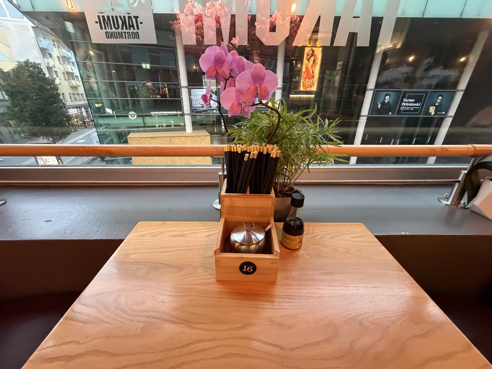 Tischdetail an einem Fensterplatz bei Takumi Dortmund: Stäbchen, Sojasauce und Orchidee vor der Fensterfront